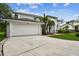 Desirable two-story home featuring a manicured lawn, a two-car garage, and lush tropical landscaping at 16003 Ridley Pl, Tampa, FL 33647