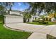 Inviting two-story home featuring a manicured lawn, a two-car garage, and lush tropical landscaping at 16003 Ridley Pl, Tampa, FL 33647