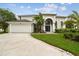 Charming two-story home with a well-manicured lawn, arched entry, and a convenient two-car garage at 16003 Ridley Pl, Tampa, FL 33647