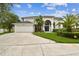 Charming two-story home with a well-manicured lawn, arched entry, and a convenient two-car garage at 16003 Ridley Pl, Tampa, FL 33647