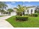 This home has a manicured lawn and colorful landscaping, along with a curved driveway and a white garage door at 16003 Ridley Pl, Tampa, FL 33647