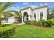 Beautiful two-story home featuring lush landscaping, a well-manicured lawn, and elegant architectural details at 16003 Ridley Pl, Tampa, FL 33647