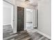 Bright hallway with modern wood-look floors, white walls, and multiple doorways at 16003 Ridley Pl, Tampa, FL 33647