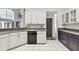 Kitchen showcasing white cabinetry, tile flooring, stainless steel appliances, and backyard view at 16003 Ridley Pl, Tampa, FL 33647