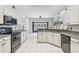 Bright kitchen with white cabinetry, tile flooring, and stainless steel appliances, and bay window at 16003 Ridley Pl, Tampa, FL 33647
