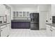 Kitchen features stainless steel appliances, white and purple cabinets, grey countertops, and white tile flooring at 16003 Ridley Pl, Tampa, FL 33647
