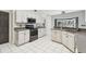 Bright kitchen features white cabinetry, modern appliances, and grey countertops with white tile flooring at 16003 Ridley Pl, Tampa, FL 33647