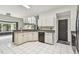 Well-lit kitchen features stainless steel appliances, white cabinets, grey countertops, and white tile flooring at 16003 Ridley Pl, Tampa, FL 33647