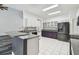 Spacious kitchen with stainless steel appliances, white cabinets, grey countertops, and white tile flooring at 16003 Ridley Pl, Tampa, FL 33647