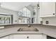 Open kitchen with quartz countertops and stainless steel sink with a backyard view, and white cabinets at 16003 Ridley Pl, Tampa, FL 33647