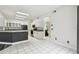 Open concept kitchen includes modern appliances, white cabinets, grey countertops, and white tile flooring at 16003 Ridley Pl, Tampa, FL 33647