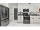 Kitchen features white cabinets, gray countertops, and stainless steel appliances, plus backyard access at 16003 Ridley Pl, Tampa, FL 33647