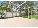 Spacious screened lanai with concrete floors and views of lush greenery, perfect for outdoor relaxation and entertaining at 16003 Ridley Pl, Tampa, FL 33647