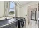 Laundry room featuring a modern washer and dryer set plus access to both the bathroom and the backyard at 16003 Ridley Pl, Tampa, FL 33647