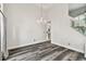 Elegant living room featuring gray wood floors, chandelier, and staircase with glass wall at 16003 Ridley Pl, Tampa, FL 33647