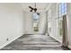 Bright living room with gray wood floors, tall arch windows, and modern ceiling fan at 16003 Ridley Pl, Tampa, FL 33647
