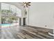 Bright living room with high ceilings, wood floors, and a view of the screened-in pool area at 16003 Ridley Pl, Tampa, FL 33647