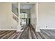 Open-concept living room with gray wood floors, staircase, and view to a backyard pool at 16003 Ridley Pl, Tampa, FL 33647
