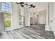 Spacious living room with tall arch windows, gray wood floors, and elegant chandelier at 16003 Ridley Pl, Tampa, FL 33647