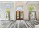 Grand living room with tall arch windows, gray wood floors, and elegant wood front door at 16003 Ridley Pl, Tampa, FL 33647