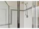 Modern shower with a glass door and white tiled surround with decorative border at 16003 Ridley Pl, Tampa, FL 33647