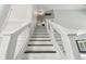 Bright staircase featuring a white banister, glass panels, and modern black and white steps at 16003 Ridley Pl, Tampa, FL 33647