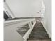 Top view of a staircase with white banister, glass panels, and wood look flooring on the landing at 16003 Ridley Pl, Tampa, FL 33647
