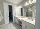Bathroom featuring double sinks, ample counter space, and a view to a walk-in closet at 16126 San Donato Pl, Bradenton, FL 34211