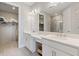 Bathroom featuring dual sinks, quartz countertop, and a glass-enclosed shower, complemented by a spacious walk-in closet at 16126 San Donato Pl, Bradenton, FL 34211
