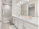 Bright bathroom featuring double sinks, white cabinetry, and a large mirror at 16126 San Donato Pl, Bradenton, FL 34211