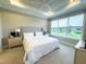 Sunlit bedroom with large windows offering water views, featuring a comfortable bed and bedside lamps at 16126 San Donato Pl, Bradenton, FL 34211