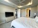 Well-lit bedroom featuring a queen-size bed, a ceiling fan and a TV above a dresser at 16126 San Donato Pl, Bradenton, FL 34211