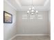 Bright dining room featuring elegant chandelier, neutral paint, tray ceiling and an artistic touch with a framed painting at 16126 San Donato Pl, Bradenton, FL 34211