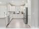 Bright kitchen with white cabinets, stainless steel appliances, gray tiled flooring, and ample counter space at 16126 San Donato Pl, Bradenton, FL 34211