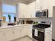 Modern kitchen with white cabinetry, stainless steel appliances, and a tile backsplash at 16126 San Donato Pl, Bradenton, FL 34211