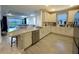 Open kitchen with white cabinets, stainless steel appliances, and a breakfast bar, seamlessly flowing into the living area at 16126 San Donato Pl, Bradenton, FL 34211