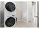 Modern laundry area with stackable washer and dryer, featuring sleek tile flooring at 16126 San Donato Pl, Bradenton, FL 34211