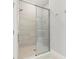 Modern glass shower enclosure featuring a rainfall shower head, bench, and tiled walls for a spa-like experience at 16126 San Donato Pl, Bradenton, FL 34211
