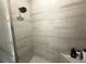 Bathroom shower features gray tiled walls, a shower head, and a built-in seat at 16126 San Donato Pl, Bradenton, FL 34211