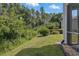 Private backyard with mature landscaping and a partial view of the screened-in patio at 1827 Hammocks Ave # 1303, Lutz, FL 33549