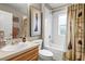 Clean bathroom with a large sink and vanity, toilet, and shower-tub combination with charming curtain at 1827 Hammocks Ave # 1303, Lutz, FL 33549
