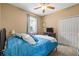 Cozy bedroom features a ceiling fan, neutral carpet, and a full-sized bed with blue patterned bedding at 1827 Hammocks Ave # 1303, Lutz, FL 33549
