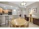 Bright dining area with wood table and chairs, and a view into the adjoining kitchen at 1827 Hammocks Ave # 1303, Lutz, FL 33549