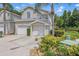 Two-story townhome featuring a two-car garage, balcony, and mature landscaping, perfect for Florida living at 1827 Hammocks Ave # 1303, Lutz, FL 33549