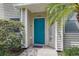 Inviting front entrance with a vibrant blue door, neutral siding, and manicured landscaping at 1827 Hammocks Ave # 1303, Lutz, FL 33549