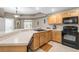 Well-maintained kitchen featuring oak cabinets, light countertops, and black appliances at 1827 Hammocks Ave # 1303, Lutz, FL 33549