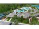 Aerial view of clubhouse, playground, and pool with palm trees, tennis courts, and surrounding trees at 20109 Bay Cedar Ave, Tampa, FL 33647