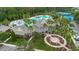 Aerial view of the clubhouse, pool with slide, tennis courts, water feature and palm trees at 20109 Bay Cedar Ave, Tampa, FL 33647