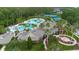 Aerial view of the clubhouse, community pool with slide, tennis courts, parking and palm trees at 20109 Bay Cedar Ave, Tampa, FL 33647
