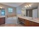 Bathroom featuring a corner tub, tiled floors, and vanities, and a walk-in shower at 20109 Bay Cedar Ave, Tampa, FL 33647